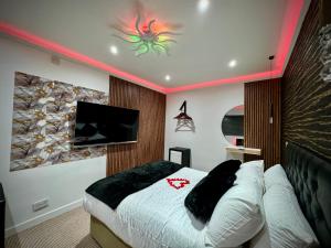 a bedroom with a bed and a tv on the wall at Suite 1 Private Jacuzzi Spa Hot Tub & Sauna in Attercliffe