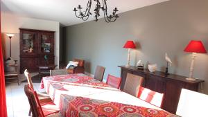 a dining room with a table and chairs and a chandelier at Les Flamants in Portiragnes