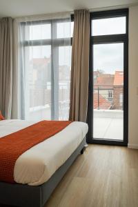 une chambre avec un lit et une grande fenêtre dans l'établissement Appartment Veeweyde 5, à Bruxelles