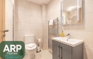 a bathroom with a toilet and a sink at Green Park House, Private Garage and Parking in Coventry