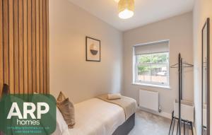 a bedroom with a bed and a window at Green Park House, Private Garage and Parking in Coventry
