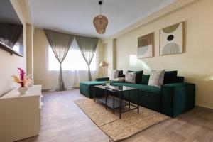 a living room with a green couch and a table at Élégant 2BR au cœur de Hassan by MERAT HOME in Rabat