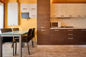 a kitchen with a table and chairs and a microwave at San Vincenzo San Luigi 261 in San Vincenzo +15 photos
