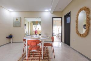 a dining room with a table and chairs and a mirror at Élégant 2BR au cœur de Hassan by MERAT HOME in Rabat