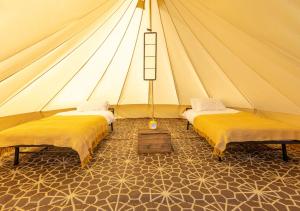 a tent with two beds in a room at Nine Yards Bell Tents at the TT - Castletown in Castletown