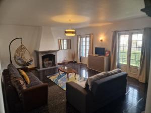 a living room with two couches and a fireplace at Pascoal House in Ribeira Grande