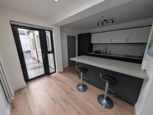 a kitchen with a counter and two bar stools at Quiet Private Room in Prime Location in Derry Londonderry +4 photos