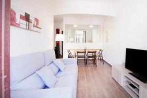 a living room with a white couch and a table at Apartamento Sant Gervasi in Barcelona