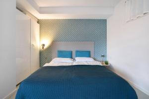 a bedroom with a large bed with blue sheets at Modernes Apartment Ammersee in Windach