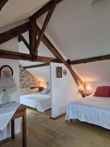 Gite Le Pré Des Colombes في Saint-Martin-Sepert: غرفة نوم بسريرين في العلية