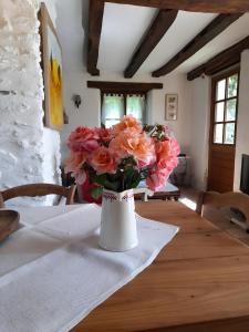 Gite Le Pré Des Colombes في Saint-Martin-Sepert: مزهرية مليئة بالورود الزهري تجلس على طاولة +12 صورة