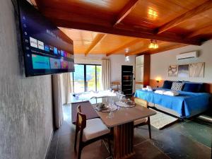 a living room with a couch and a tv at Cabana Tesouros do Baú in São Bento do Sapucaí