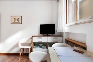 Cornedo all'IsarcoHaus Marlene的配有电视、桌椅的客厅