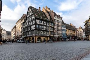 un bâtiment au milieu d'une rue de la ville dans l'établissement Charmant et typique 2 pièces Place de la Cathédrale, à Strasbourg