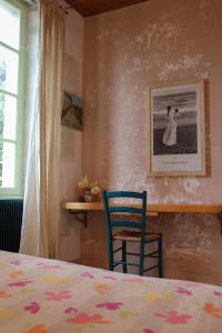 a bedroom with a bed and two chairs at Le Couvent in LʼHermenault +25 photos