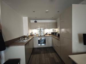 a kitchen with white cabinets and a sink at Cozy 1 Bedroom Apartment Retreat in West Thurrock +6 photos