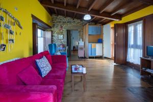 ein Wohnzimmer mit einem roten Sofa und einem Tisch in der Unterkunft Casa Souto De Abajo Adaptada in Santiso