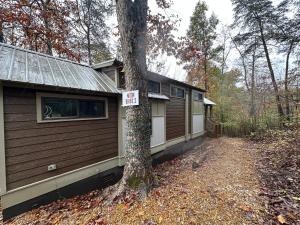 a house with a no parking sign next to a tree at Moon River Mentone 2-A Riverfront Tiny Home in Mentone