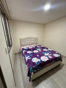 1 dormitorio con 1 cama con edredón morado en Apartmento Úbate, en Ubaté