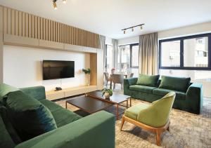 a living room with green couches and a tv at Hotel Koncept Residence in Sarajevo
