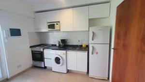 a kitchen with white appliances and a washer and dryer at Monoambiente encantador en Nuñez in Buenos Aires