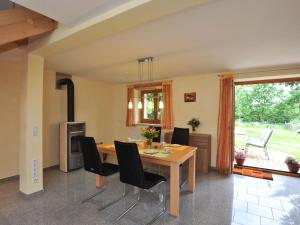 a dining room with a wooden table and black chairs at Ferienhaus am Kropbach in Staufen