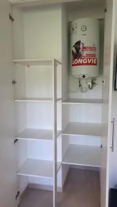a white closet with white shelves in a room at Monoambiente encantador en Nuñez in Buenos Aires