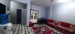 a living room with a red couch and a carpet at Downtown Apartment in Aswan