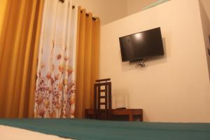 a bedroom with a flat screen tv on the wall at Natura in Dickwella