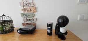 a desk with a black coffee maker and a cup at Fascinante Orbita Apartments in Vila Nova de Famalicão +12 photos