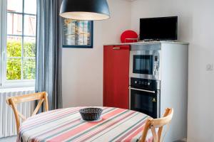 a small kitchen with a table and a red refrigerator at Entre Terre et Mer in Ciboure