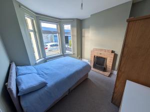 a bedroom with a bed and a fireplace at Quiet Private Room in Prime Location in Derry Londonderry