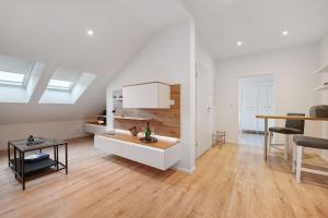 GeestlandにあるFerienwohnung Moor, Marsch und Meerのテーブルとキッチンのある白いリビングルーム