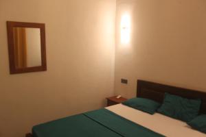 a bedroom with a bed and a mirror on the wall at Natura in Dickwella