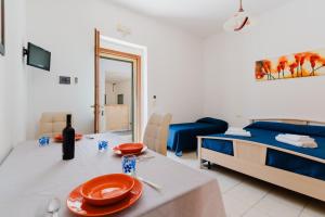 sala de estar con mesa de comedor y cama en La casetta 462, en Torre San Giovanni
