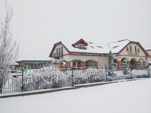 a fence in front of a house covered in snow at Farma Loreta in Vlašim