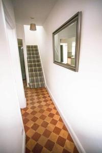 ein Flur mit Spiegel und Schachbrettmuster in der Unterkunft Stone's Throw // Central Newquay // Parking in Newquay