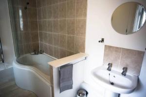ein Badezimmer mit Waschbecken, Badewanne und Toilette in der Unterkunft Stone's Throw // Central Newquay // Parking in Newquay + 9 Fotos