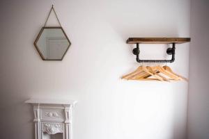 ein Spiegel hängt an einer Wand neben einem Regal in der Unterkunft Stone's Throw // Central Newquay // Parking in Newquay