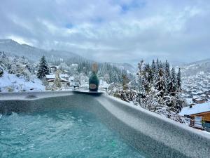 a bottle of wine sitting on top of a hot tub at Chalet Luxury 5-Les Gets-Luxe-confort-jacuzzi-à 400 m des pistes et vue montagne Mont Chéry in Les Gets