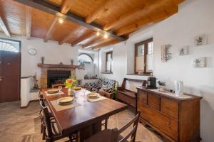 Un comedor con mesa y chimenea. en Casa Dei Pasqui' tra i monti, en Bollone