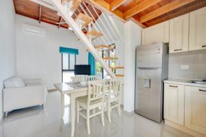 une cuisine avec une table et un réfrigérateur dans l'établissement Villaggio 6 Parque al Lago, Playa Potrero, à Potrero