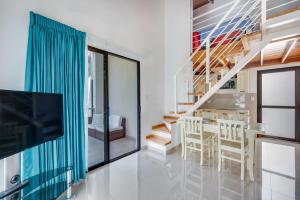 - un salon avec un escalier, une table et des chaises dans l'établissement Villaggio 6 Parque al Lago, Playa Potrero, à Potrero