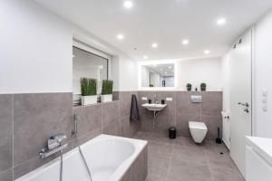 a bathroom with a tub and a toilet and a sink at Ferienwohnung Panoramanest in Balve +19 photos