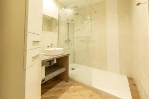 アンデルノ・レ・バンにあるAppartement Thiers in Andernosの洗面台とシャワー付きの白いバスルーム