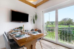 a dining room with a table and a large window at Ferienwohnung In Der Weinig in Sasbach am Kaiserstuhl