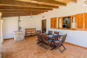 a dining room with a table and chairs and a fireplace at Villa Moreno in Pollença