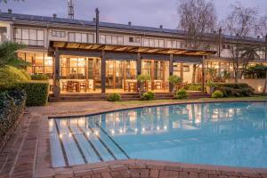 een exterieuraanzicht van een huis met een zwembad bij Graskop Hotel in Graskop