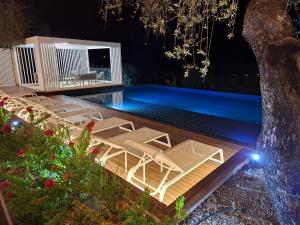 a pool with chaise lounge chairs and a swimming pool at Borgo Nocchiara in Carlentini