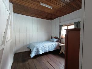 a bedroom with a bed in the corner of a room at Downtown cabin for families in Macas in Macas
